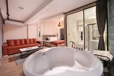 a bathroom with a tub and a living room at Harbiye Residence in Istanbul
