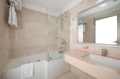 a bathroom with a tub and a sink and a mirror at Emporium Hotel in Istanbul