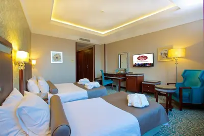 a hotel room with two beds and a desk at Emporium Hotel in Istanbul