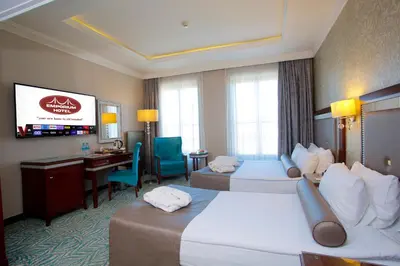 a hotel room with two beds and a desk at Emporium Hotel in Istanbul