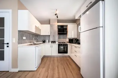 a kitchen with white cabinets and a refrigerator at Çırağan Apart Bosphorus in Istanbul