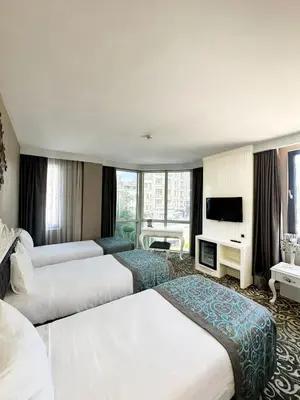 a hotel room with two beds and a television at Taksim Line Hotel in Istanbul