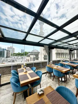 a restaurant with tables and chairs and a large window at Taksim Line Hotel in Istanbul