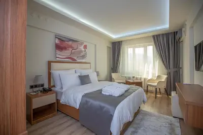 a hotel room with a large bed and a desk at Kutlucan Oldtown in Bursa