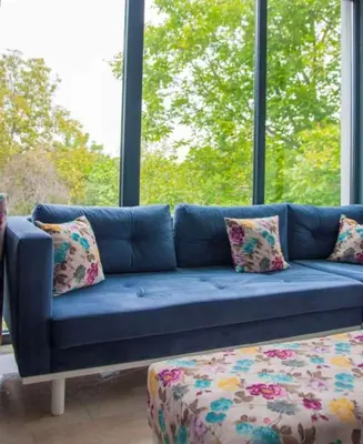 a blue couch in front of a large window at Room Room Motel in Sapanca