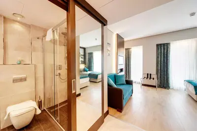 a bathroom with a shower and a blue couch in a room at Mukarnas Taksim Hotel in Istanbul