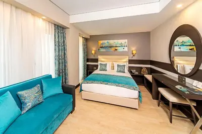 a bedroom with a bed and a blue couch at Mukarnas Taksim Hotel in Istanbul