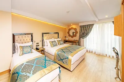 a hotel room with two beds and a window at Mukarnas Taksim Hotel in Istanbul