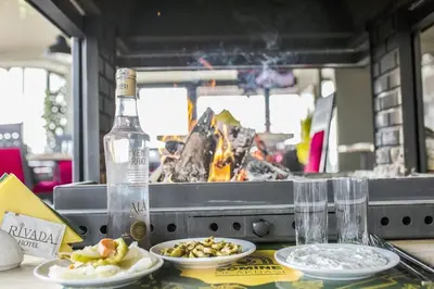 a table with plates of food and a bottle of wine at RİVADA HOTEL in Kartepe