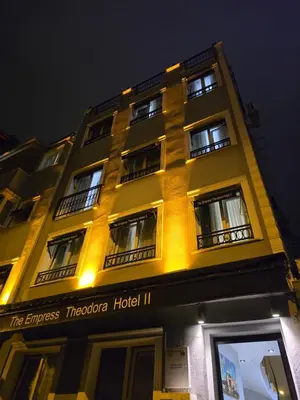 a tall yellow building with windows at night at The Empress Theodora Hotel ll in Istanbul