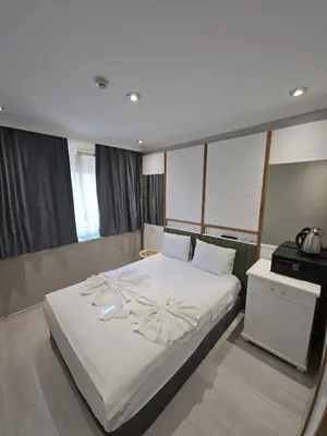 a bedroom with a large bed with white sheets at The Empress Theodora Hotel ll in Istanbul