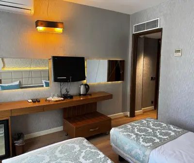 a hotel room with a bed and a desk with a television at Style Star Hotel Cihangir in Istanbul