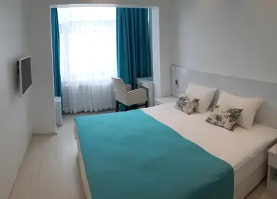 a bedroom with a large bed with a blue blanket at Payidar HOTEL in Istanbul