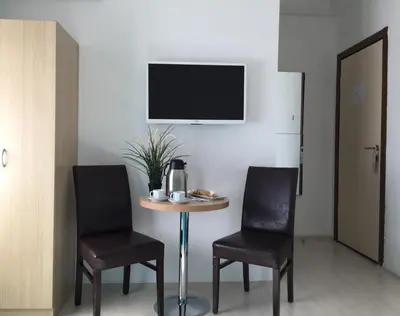 a table with two chairs and a tv on a wall at Payidar HOTEL in Istanbul
