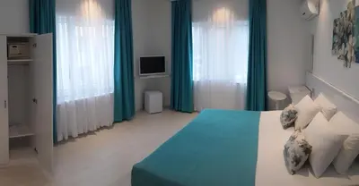 a bedroom with a blue and white bed and windows at Payidar HOTEL in Istanbul