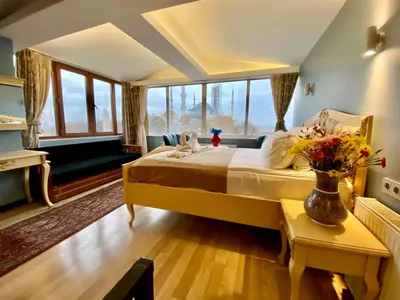 a bedroom with a large bed with a vase of flowers at Optimist Hotel in Istanbul