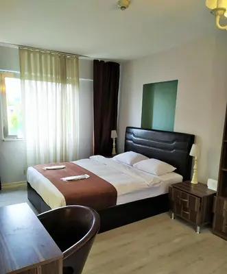 a bedroom with a bed and a chair and a table at Résidence Le Rêve in Istanbul