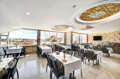 a restaurant with tables and chairs and a large window at Ayasultan Hotel in Istanbul