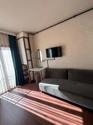 a living room with a couch and a tv on the wall at Mezzo Hotel in Istanbul