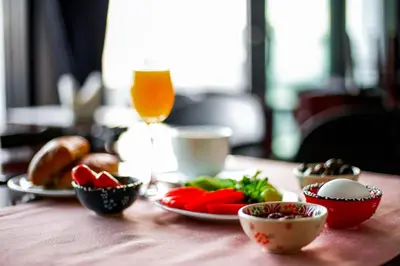 a table with plates of vegetables and a glass of orange juice at Novelty Hotel in Istanbul