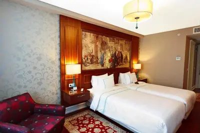 a bedroom with a large bed and a red chair at Neorion Hotel - Special Class in Istanbul