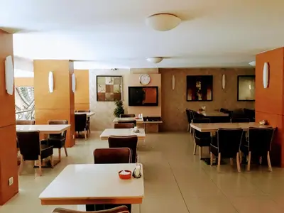 a restaurant with tables and chairs and a clock on the wall at Merdan Hotel in Istanbul