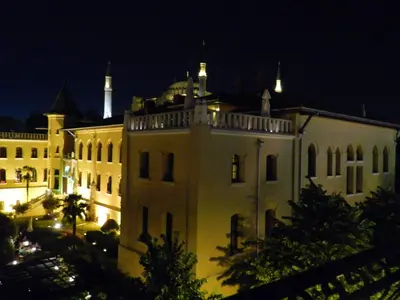 a large white building with a tower on top at night at Berk Guest House - Grandma's House in Istanbul
