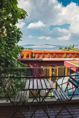 a bench and two chairs on a balcony at L'isola Guesthouse in Heybeliada