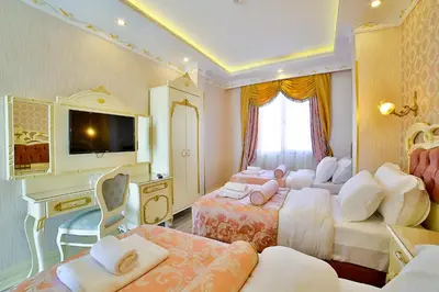 a bedroom with three beds and a tv and a desk at Nayla Palace Hotel-Special Category in Istanbul