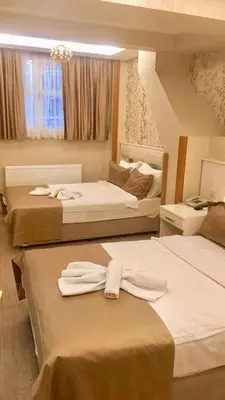 a hotel room with three beds with towels on them at ARINÇ HOTEL in Istanbul