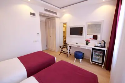 a hotel room with two beds and a desk at Albinas Hotel Old City in Istanbul