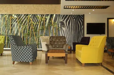 a lobby with two chairs and a tv and bamboo mural at Arya Hotel Sakarya in Sakarya
