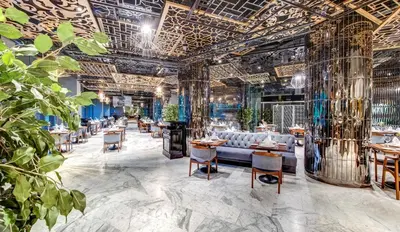 a restaurant with a couch and tables and plants at The Elysium Taksim in Istanbul