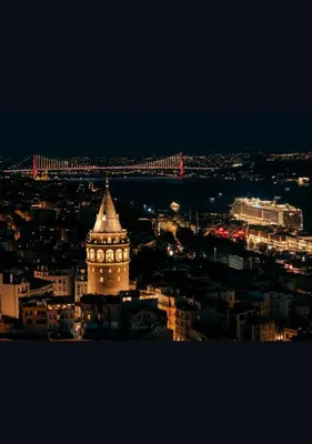 a lit up clock tower in a city at night at Ens Hotel in Istanbul