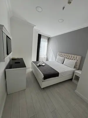 a white bedroom with a bed and a television at Ens Hotel in Istanbul