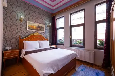 a bedroom with a bed and two windows at Gedikpasa Konagi Hotel in Istanbul