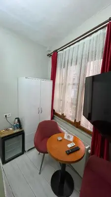 a room with a table and a red chair and a television at Chez Bore in Istanbul