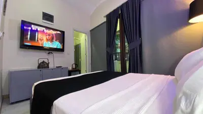 a bedroom with a white bed and a flat screen tv at Chez Bore in Istanbul