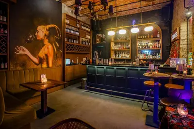 a bar with a painting of a woman on the wall at Cheers Porthouse in Istanbul