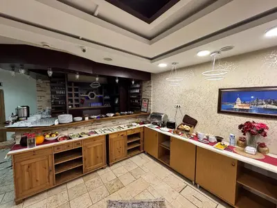 a kitchen with wooden cabinets and a flat screen tv at Hotel Ipekyolu in Istanbul