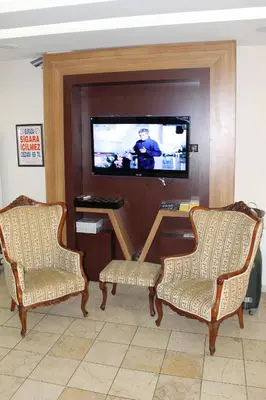 a living room with two chairs and a flat screen tv at Hotel Ipekyolu in Istanbul