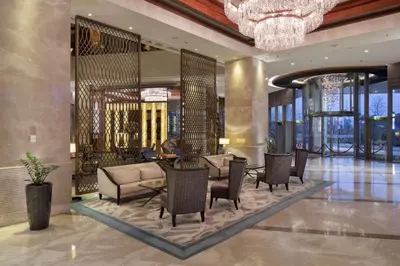 a lobby with chairs and tables and a chandelier at Hilton Bursa Convention Center & Spa in Bursa