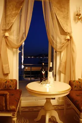 a table in front of a window with a bottle of wine at Fuat Pasa Oteli - Special Category Bosphorus in Istanbul