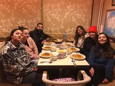 a group of people sitting around a table eating food at Second Home Suites in Istanbul