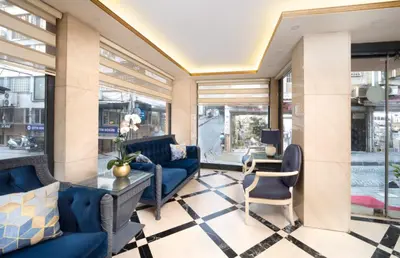 a lobby with blue couches and a table and chairs at Deluxe Newport Hotel - Old City in Istanbul