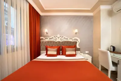 a bedroom with a large bed with orange pillows at Deluxe Newport Hotel - Old City in Istanbul