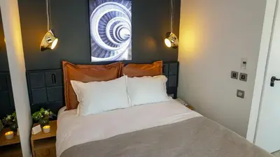 a bedroom with a bed with white sheets and a window at Maroon Tomtom in Istanbul
