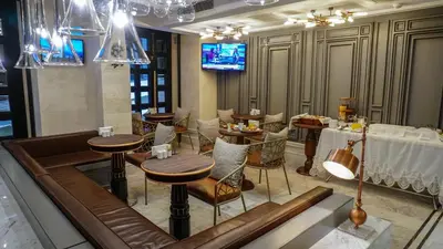 a restaurant with tables and chairs and a television at Maroon Tomtom in Istanbul