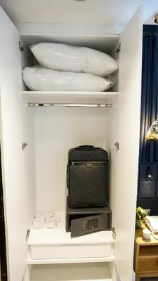 a walk in closet with white dishes and a suitcase at Maroon Tomtom in Istanbul