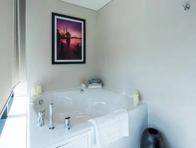 a bathroom with a white tub with a picture on the wall at Centro Westside by Rotana in Istanbul